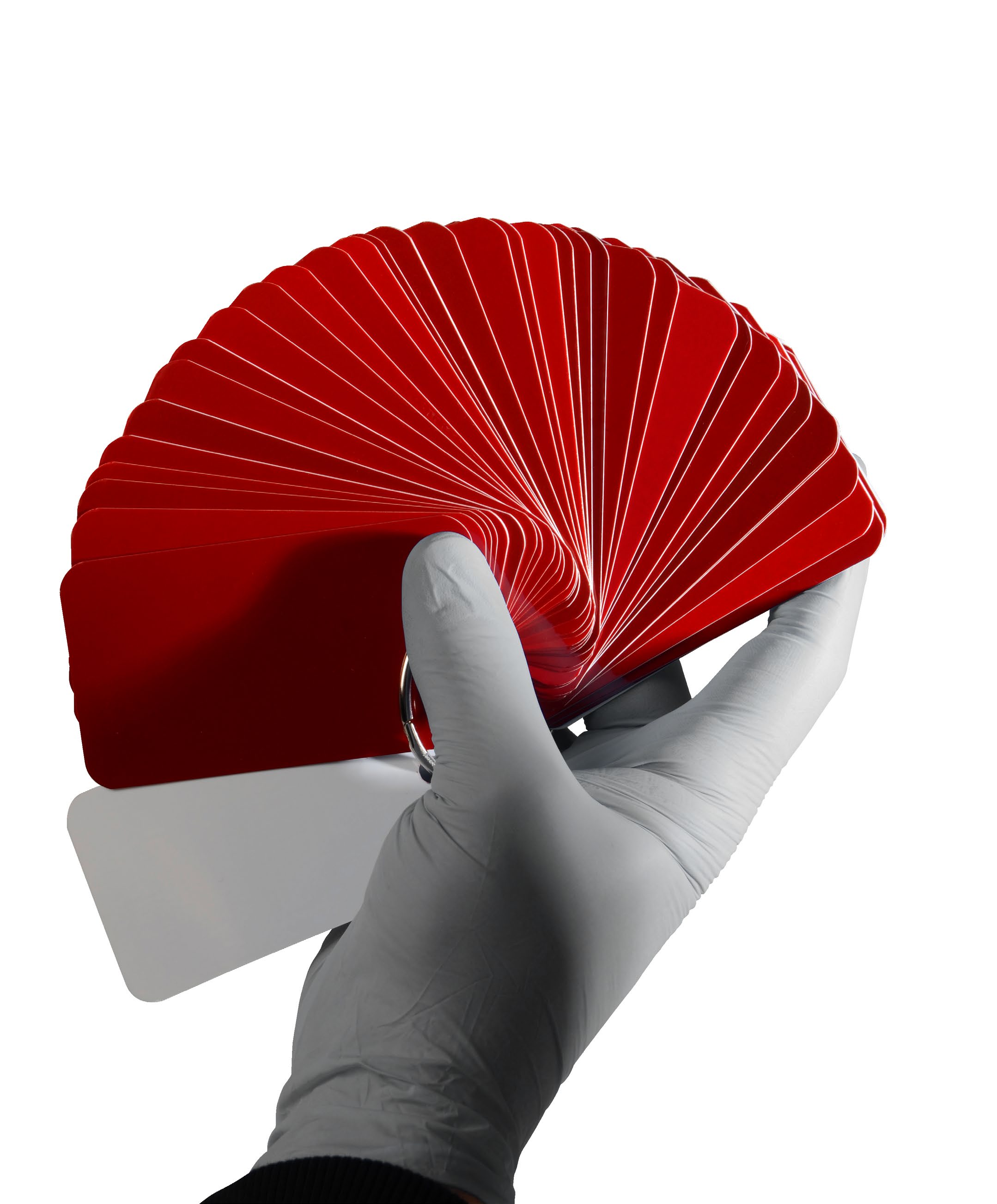 A gloved hand holding a fanned deck of red color chips